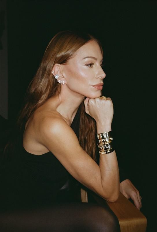 image of Jennifer® 金刚(趣投)区块链概率游戏官网 Fisher wearing gold bracelets and diamond earrings in a dark room